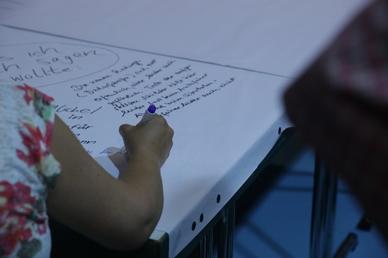 Bild: Ein Ideentisch mit einer schreibenden Hand